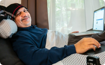 Porträt von Khalid Nadeem Arif bei der Arbeit am Laptop, als Beispiel eines Unternehmers mit Behinderung.
